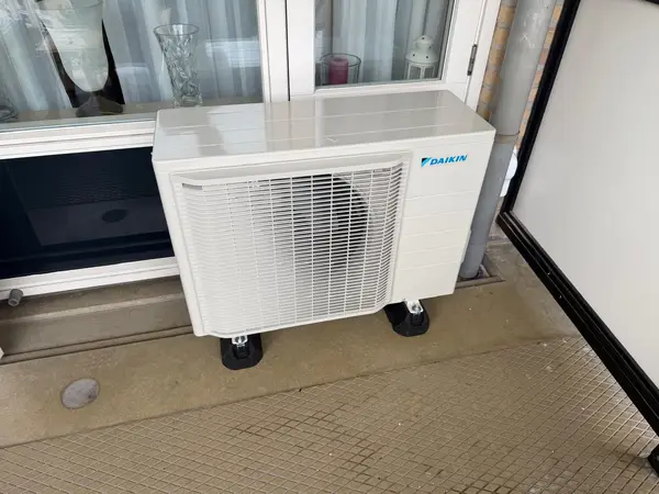 Daikin-buitenunit op trillingsdempers voor een raampartij